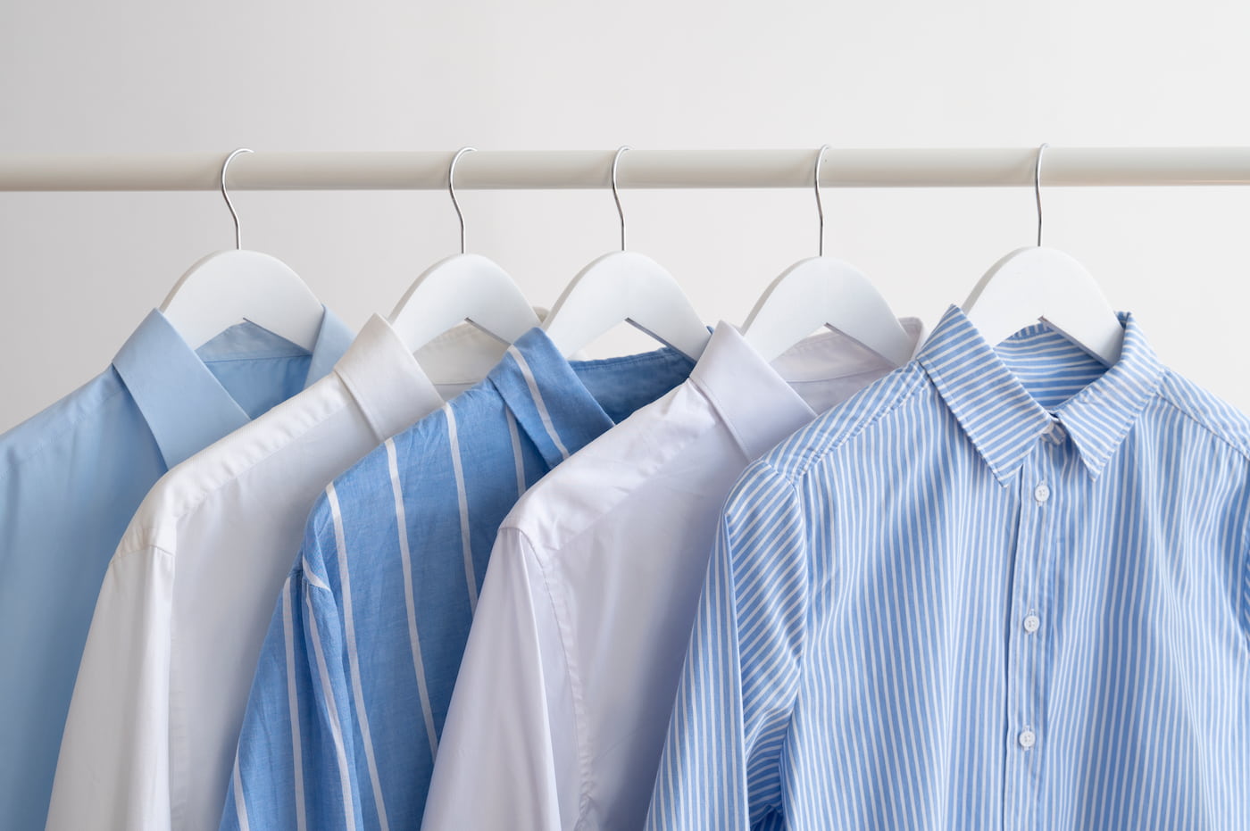 Classic shirts in blue, white, and stripes on hangers