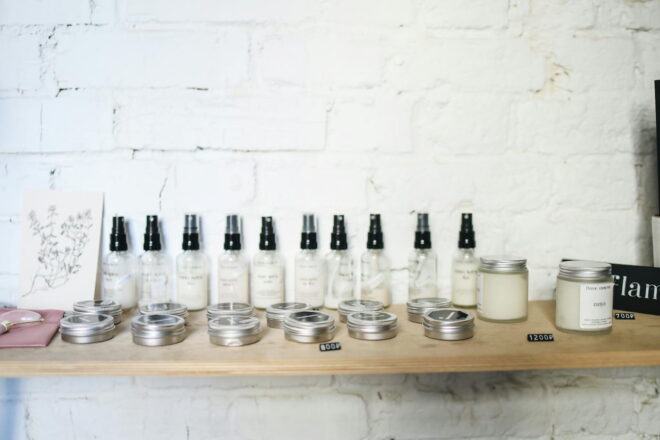 Various beauty and hair products lined up on a wooden wall shelf